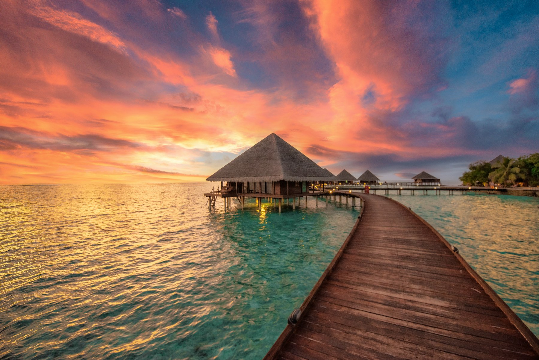 Maldives overwater villa at golden sunset