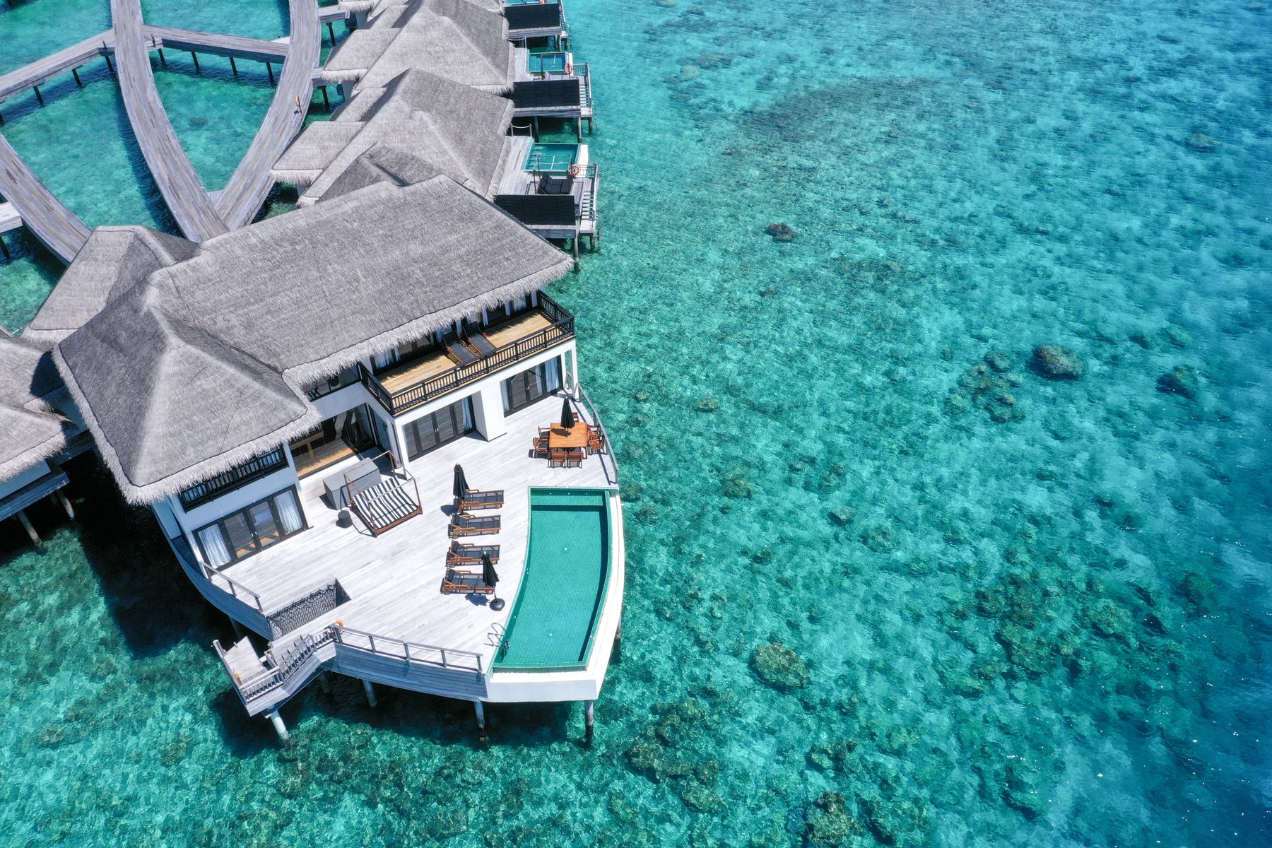 Maldives overwater villa deck with a ladder into clear turquoise water